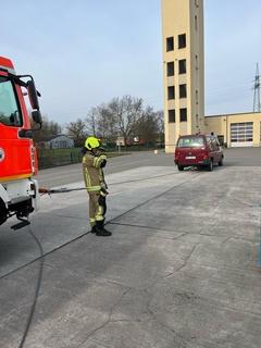 Ein Feuerwehrfahrzeug und ein MTW. Dazwischen ist ein Seil gespannt
