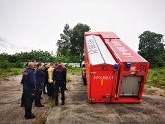HFS daneben stehen Feuerwehrleute
