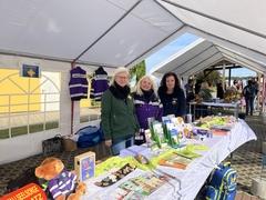 Drei Frauen am Stand unter einem Zelt