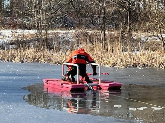 Feuerwehrmann mit Eisretter auf See