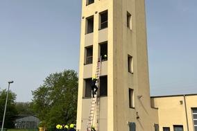Feuerwehrmänner üben am Schlauchturm mit Leitern