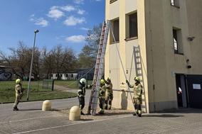 Feuerwehrmänner mit Leitern am Schlauchturm