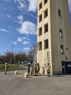 Feuerwehrmänner mit Leitern am Schlauchturm