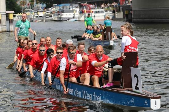 Drachenboot auf dem Wasser mit Kolleginnen und Kollegen voll besetzt