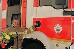 Feuerwehrfrau vor Fahrzeug