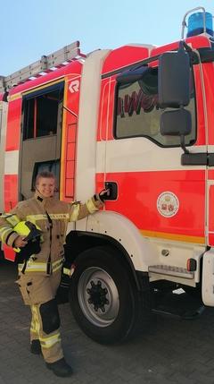 Feuerwehrfrau vor Fahrzeug