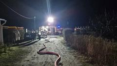 Feuerwehrauto im Dunkeln. Davor ein Schlauch und die Einsatzstelle wird mit Licht ausgeleuchtet.