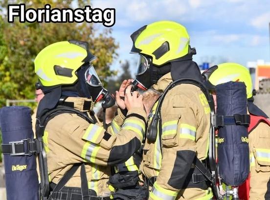 Zwei Feuerwehrmänner unter PA stehen sich gegenüber und prüfen ihre Masken