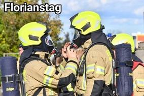 Zwei Feuerwehrmänner unter PA stehen sich gegenüber und prüfen ihre Masken