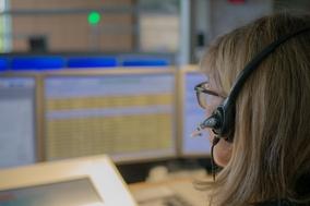 Disponentin am PC. Sie trägt Kopfhörer.