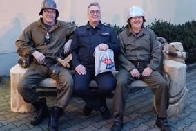 Drei Männer sitzen auf einer Bank