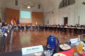 Großer Sahl. Tische stehen in einem großen Raum, an dem Männer sitzen