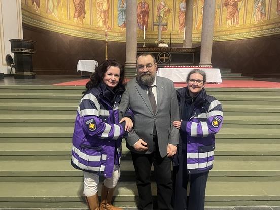 Ein Mann in der Mitte und links und rechts eine Frau, Aufnahme in der Kirche