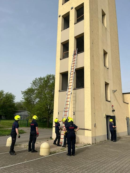 Feuerwehrmänner üben am Schlauchturm mit Leitern