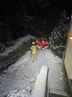 Schnee und Feuerwehrmänner an einer langen Treppe