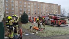 4 Feuerwehrmänner machen sich bereit zum Innenangriff. Im Hintergrund Feuerwehrfahrzeuge.