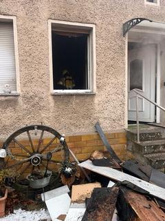 Verbrannte Utensilien aus dem Haus liegen vor dem Haus.