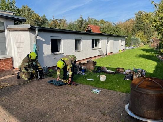 Zwei Feuerwehrmänner bei der Arbeit vor einem Haus