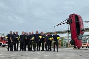 Gruppenbild mit einem Auto, welches hochkant steht