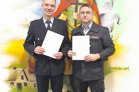 Feuerwehrmänner mit Zeugnissen in der Hand