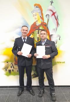 Feuerwehrmänner mit Zeugnissen in der Hand