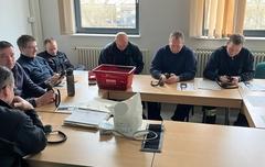 Feuerwehrmänner mit Digitalfunk im Schulungsraum