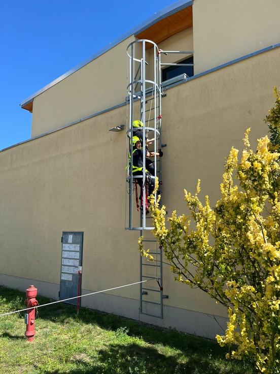 Feuerwehrmänner steigen Notleiter hinauf