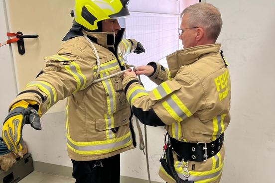 zwei Feuerwehrmänner sichern sich mit Leinen