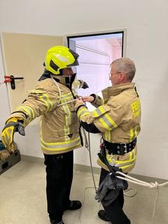 zwei Feuerwehrmänner sichern sich mit Leinen