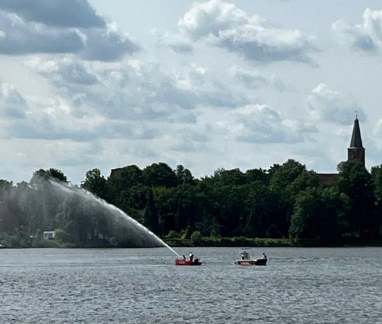 Zwei Feuerwehrboote auf dem Wasser. Von einem Boot geht eine Wasser Fontaine aus.