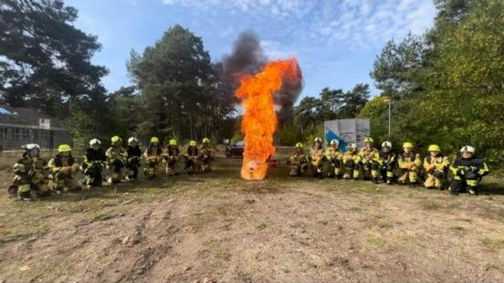 Die Brandmeisteranwärter stehen links und rechts aufgereiht und in der Mitte ist Feuer