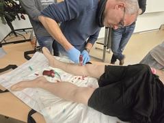 Mitarbeiter setzt Bohrer am Bein an