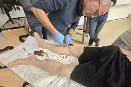 Mitarbeiter setzt Bohrer am Bein an