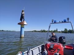 Fritze Bollmann auf dem Wasser und ein Kollegen zeigt aus dem Boot heraus auf ihn
