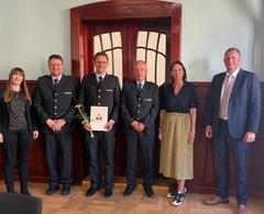 Gruppenbild mit Urkunde und Blumen