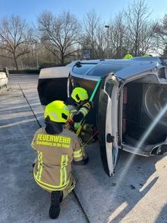 Feuerwehrmänner bei der Übung am Schrottauto. Sie stellen ein Stabilisierungssystem auf.