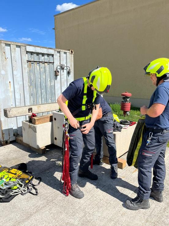 Feuerwehrmänner legen Sicherung an