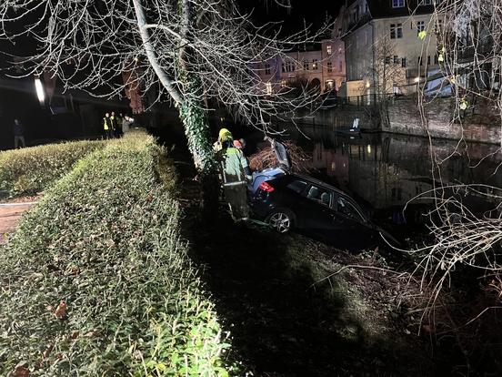 Auto an Seilwinde. Zwei Feuerwehrmänner stehen dabei.