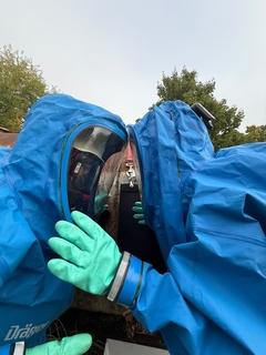 zwei Männer in blauen Schutzanzügen stehen sich direkt gegenüber mit dem Viesir Kopf an Kopf