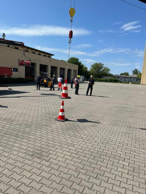 Kran der Feuerwehr hebt Verkehrskegel