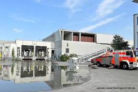 Drehleiter vor dem alten Real Markt. Man sieht eine große Wasserpfütze davor.