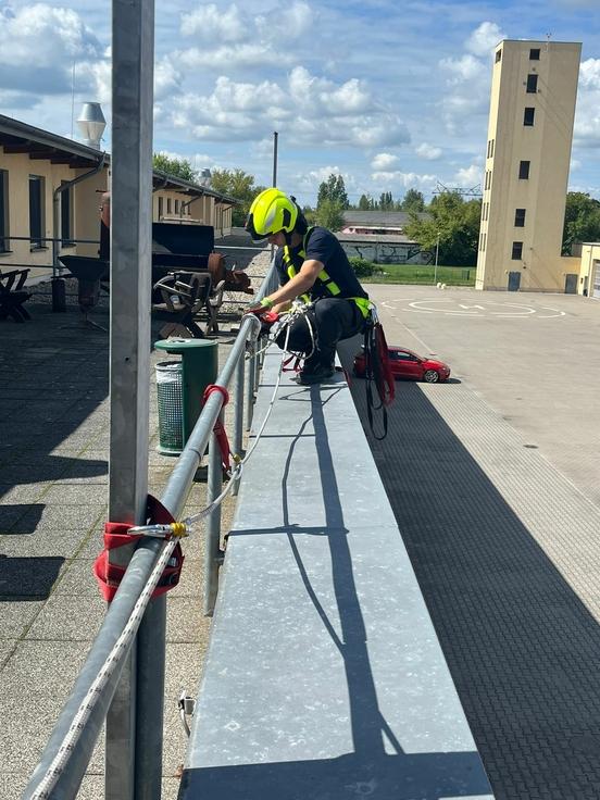 Mitarbeiter übt die Absturzsicherung, die Seile sind gut zu erkennen