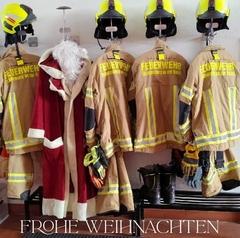 Bild von Einsatzbekleidung am Haken und dazu der Weihnachtsmannmantel