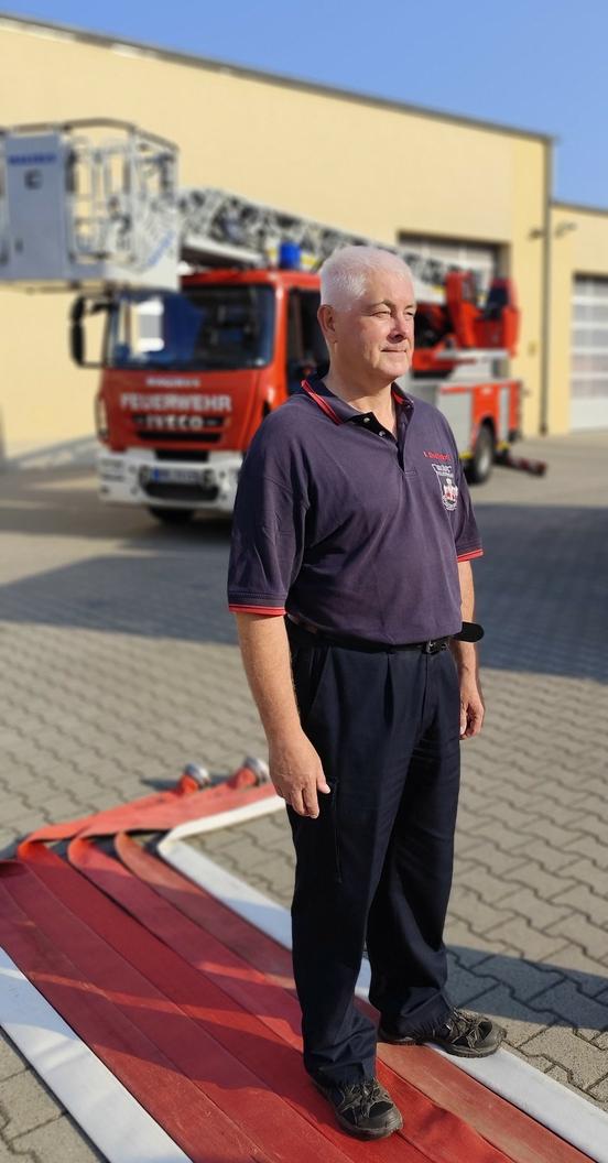 Ein Feuerwehrmann im Hintergrund die Drehleiter
