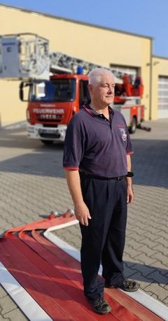 Ein Feuerwehrmann im Hintergrund die Drehleiter