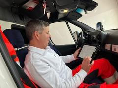 Mitarbeiter des Rettungsdienstes mit dem neuen Tablet in der Hand im Auto.