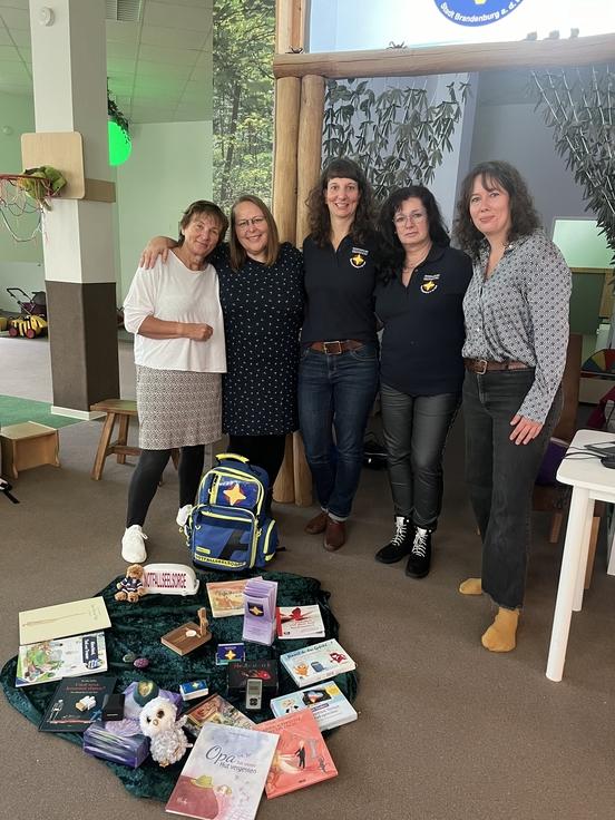 Gruppenbild mit Frauen, davor liegen Zeitungen und ein Rucksack