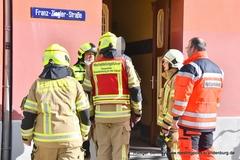 Der Einsatzleiter steht vor dem Haus und erklärt seinen Kollegen die Lage.