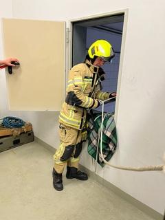 ein Feuerwehrmann hat ein Seil in der Hand