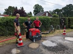 Drei Feuerwehrleute an der Straße